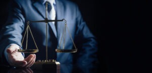 A Los Angeles mass tort and consumer class action lawyer touches a scale of justice.