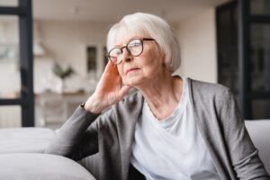 A concerned elderly woman contemplates calling a Las Vegas elder abuse lawyer.