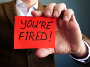 An employer holds a note that reads, ‘You’re fired.’ Contact a Las Vegas wrongful termination lawyer now.