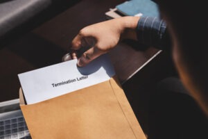 A person opens a termination letter before calling a Culver City wrongful termination lawyer.