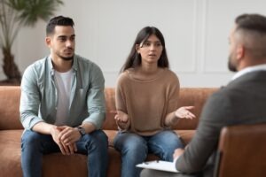 a young dad and his teenage daughter seated across from a sexual abuse lawyer