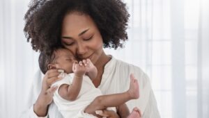 A mother snuggles her baby before calling a San Jose birth injury lawyer.