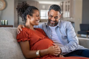 A pregnant couple smiles at each other. Hire a Las Vegas birth injury lawyer.