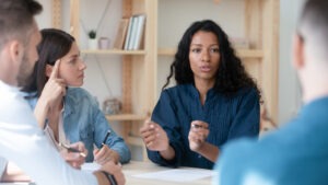 A lawyer and her clients sit around a table, and she answers their question, “Is sexual abuse a felony in California?”