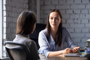 A lawyer sitting with her client and answering her questions about whether she will have to testify in her sexual abuse case.